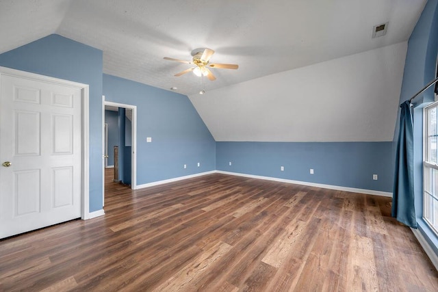 bonus room with lofted ceiling, dark wood finished floors, and baseboards