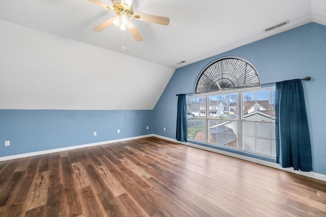 bonus room featuring wood finished floors, a ceiling fan, visible vents, vaulted ceiling, and baseboards