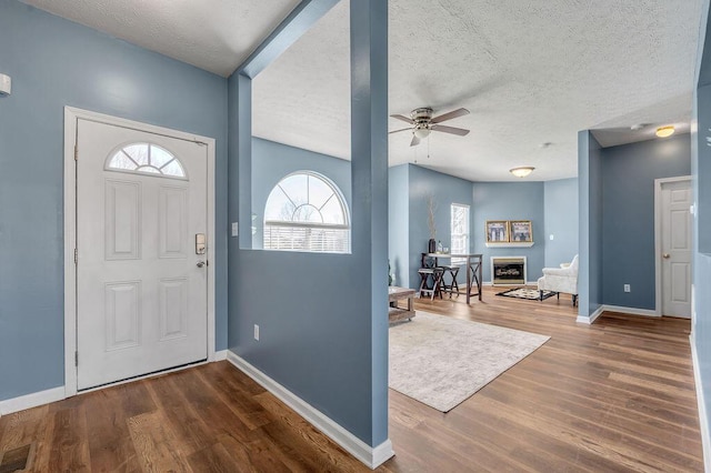 entrance foyer featuring a ceiling fan, baseboards, visible vents, and wood finished floors