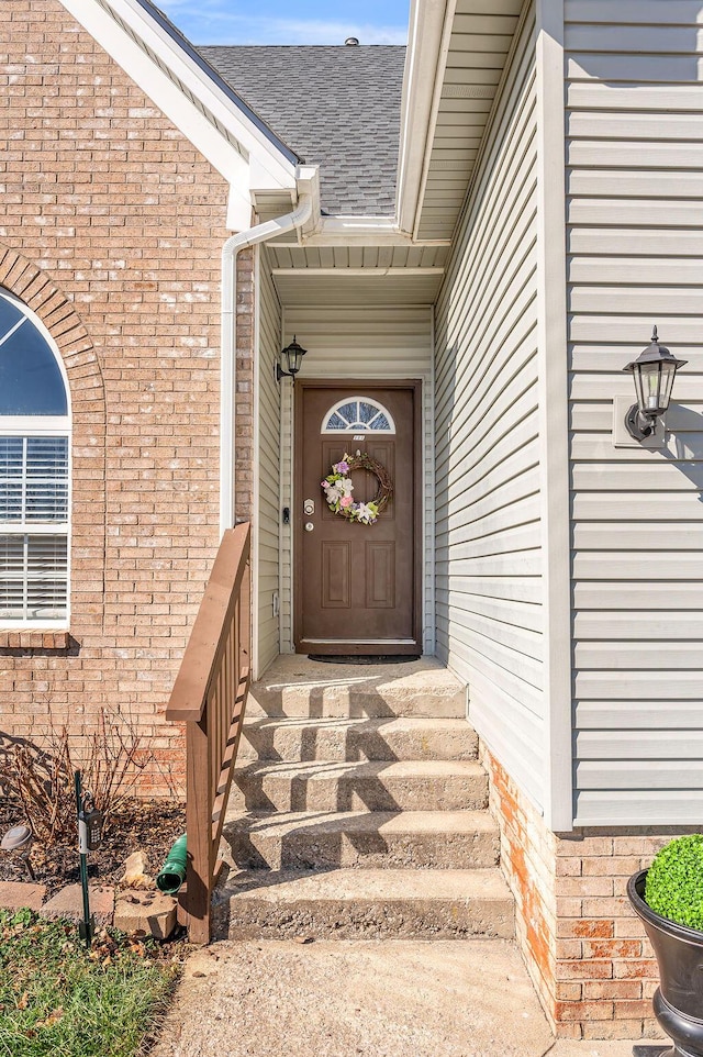 property entrance with brick siding and roof with shingles