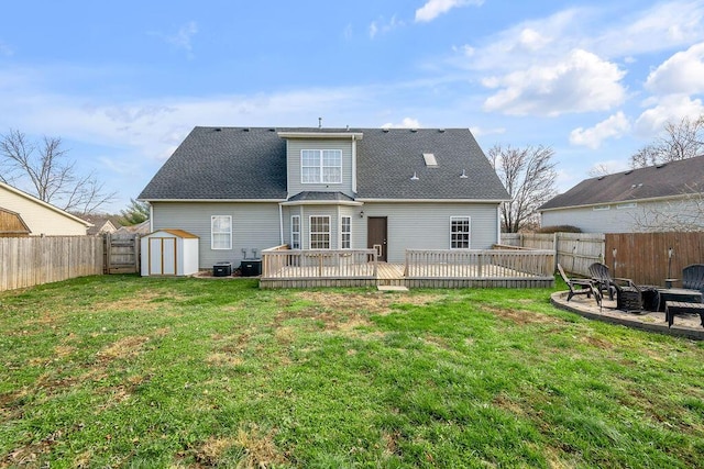 back of property featuring a deck, an outdoor fire pit, a fenced backyard, a storage shed, and an outdoor structure