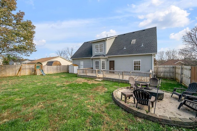 rear view of house with an outdoor fire pit, a patio, a lawn, and a fenced backyard