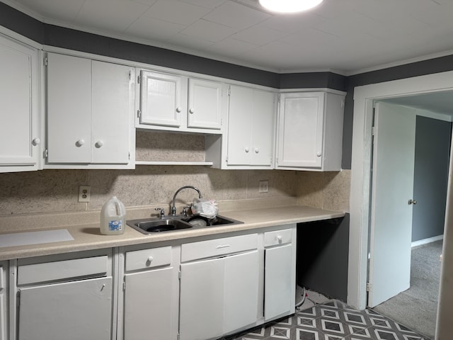 kitchen featuring white cabinetry, sink, and crown molding