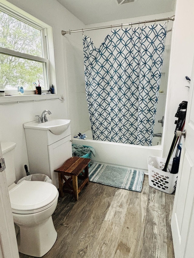 full bathroom with hardwood / wood-style floors, vanity, toilet, and shower / bathtub combination