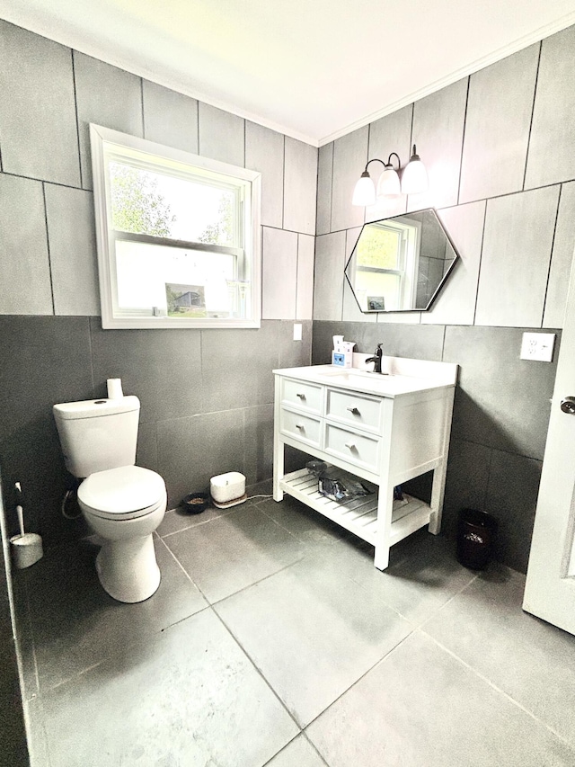 bathroom with tile patterned floors, vanity, toilet, and tile walls