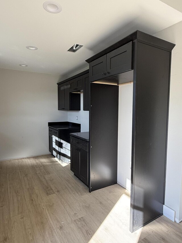 kitchen with light wood-type flooring and lofted ceiling