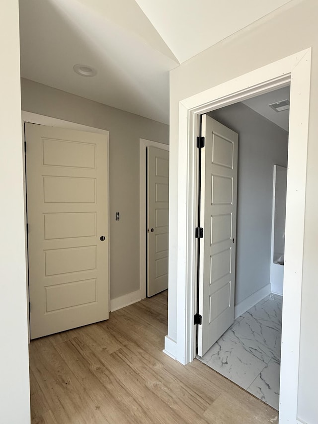 hallway with light hardwood / wood-style floors