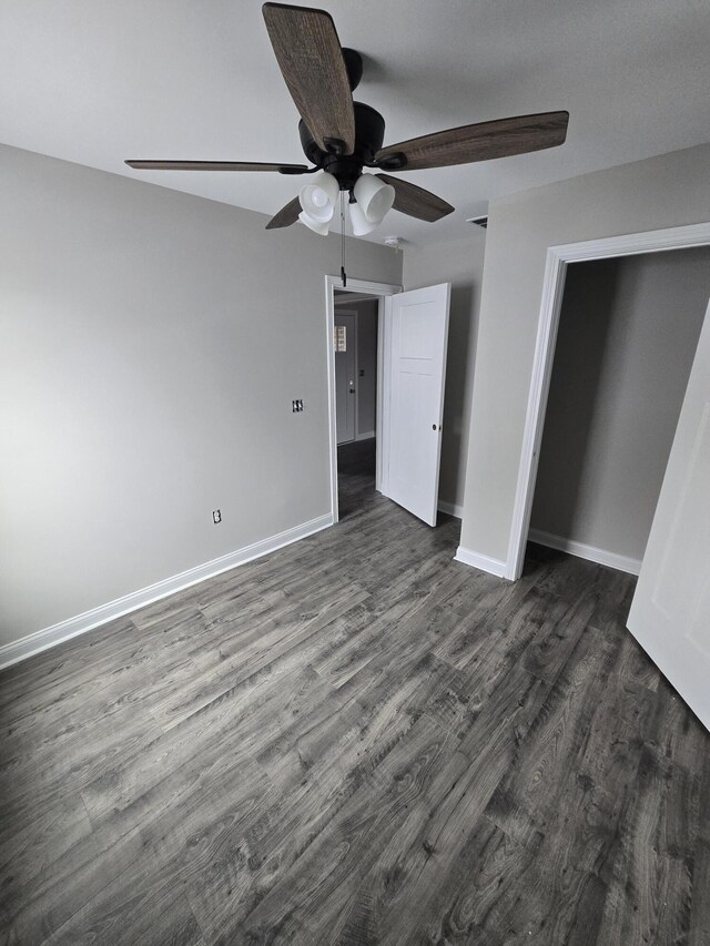 unfurnished bedroom featuring ceiling fan and dark wood-type flooring