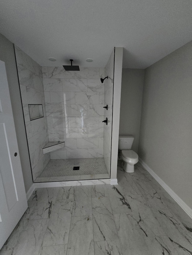 bathroom featuring a tile shower, toilet, and a textured ceiling