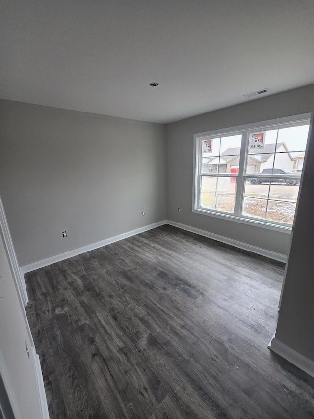 unfurnished room with dark wood-type flooring