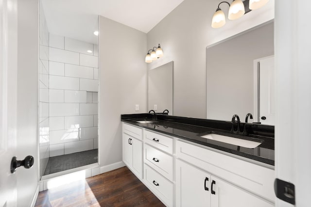 bathroom featuring hardwood / wood-style floors, vanity, and tiled shower