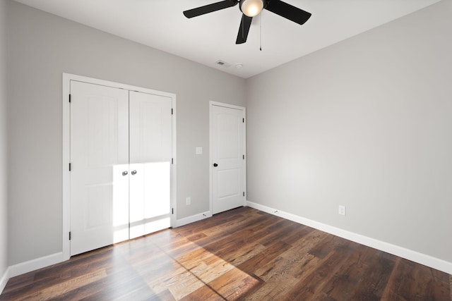 unfurnished bedroom with ceiling fan, dark hardwood / wood-style flooring, and a closet