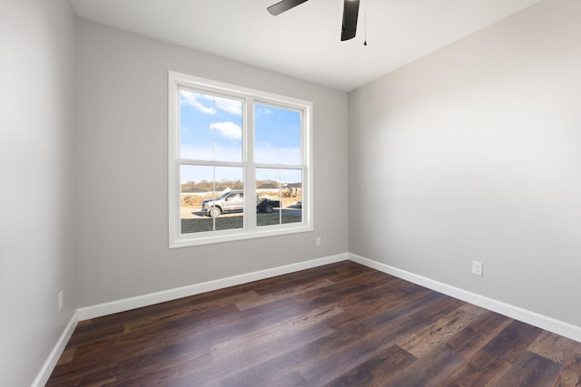 empty room featuring ceiling fan, a healthy amount of sunlight, and dark wood-type flooring