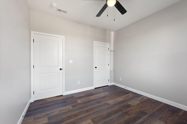 unfurnished bedroom with ceiling fan and dark wood-type flooring