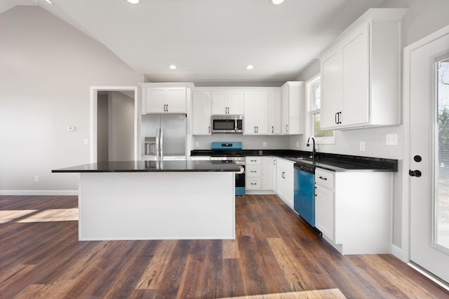 kitchen with white cabinets, a kitchen island, dark hardwood / wood-style flooring, and appliances with stainless steel finishes