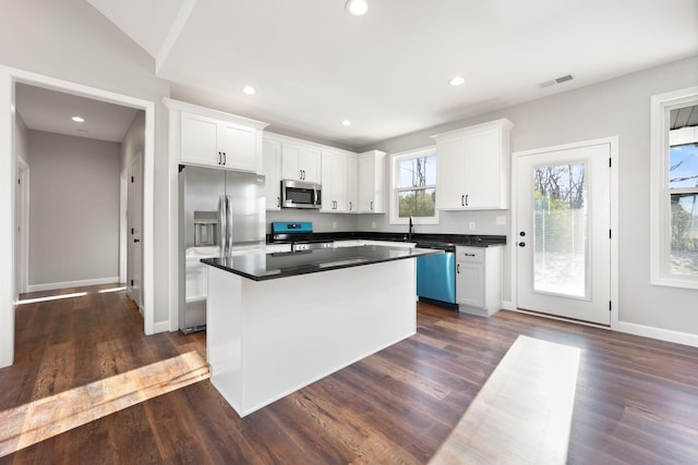 kitchen featuring a kitchen island, white cabinetry, and appliances with stainless steel finishes