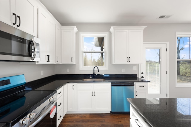 kitchen featuring dark wood-type flooring, white cabinetry, sink, and stainless steel appliances