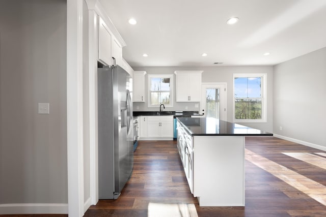 kitchen with dark wood-type flooring, white cabinets, sink, stainless steel refrigerator with ice dispenser, and a kitchen island