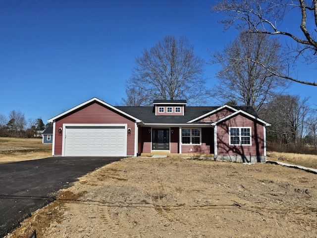 view of front of home with a garage, roof with shingles, and driveway