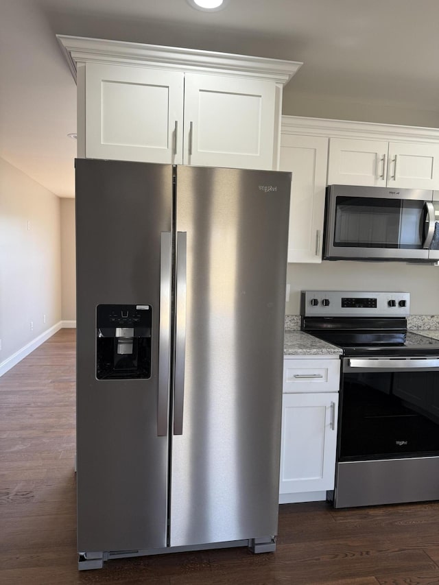 kitchen featuring dark wood-style floors, appliances with stainless steel finishes, and white cabinetry