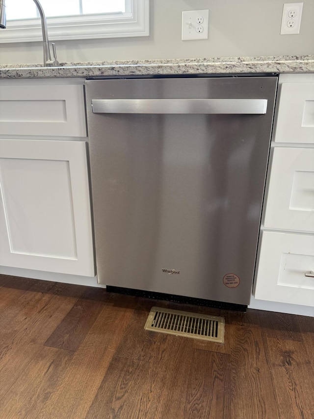 interior details featuring dark wood finished floors, white cabinets, dishwasher, and a sink