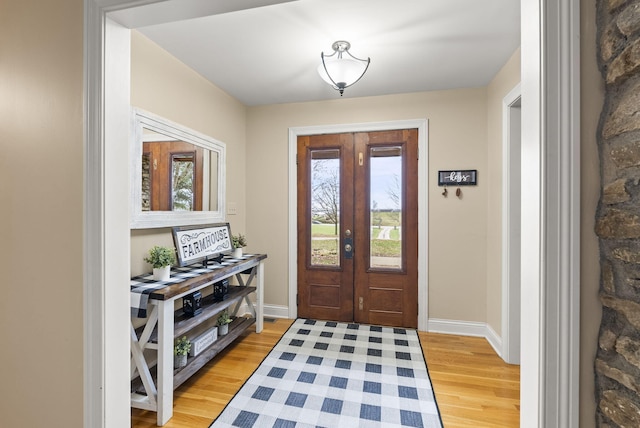 foyer with plenty of natural light, light hardwood / wood-style flooring, and french doors