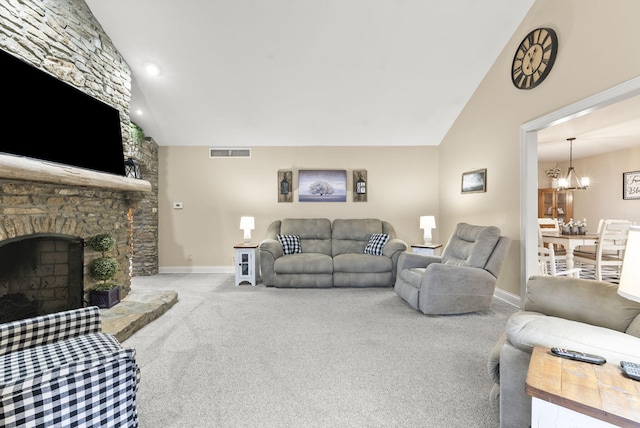 living room featuring a fireplace, light carpet, a chandelier, and vaulted ceiling