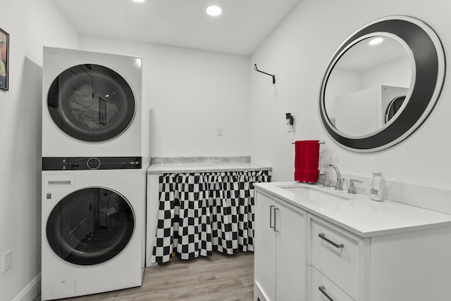 laundry room with light hardwood / wood-style floors, sink, and stacked washer and clothes dryer