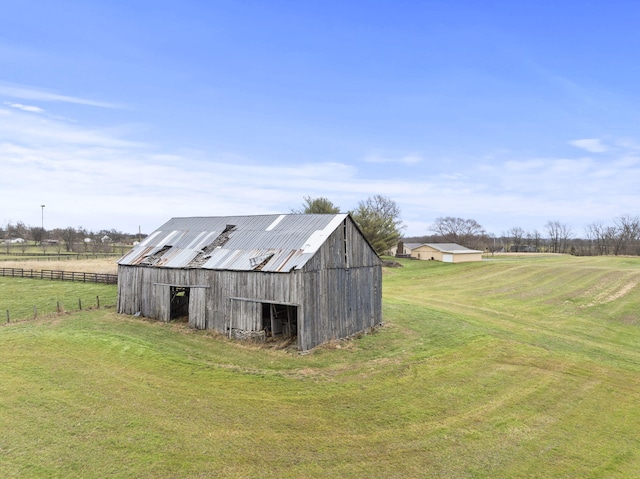 view of outbuilding with a lawn and a rural view