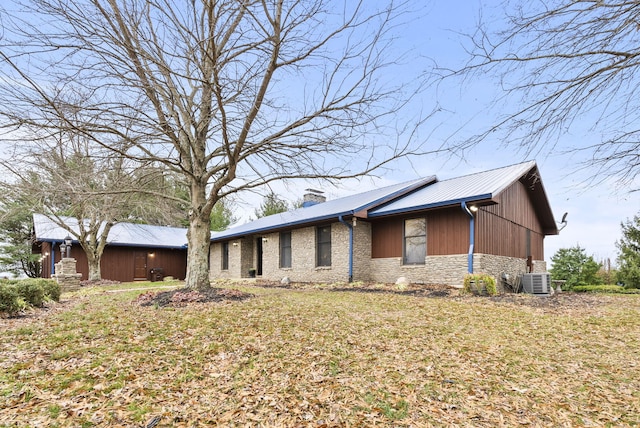 view of front of house featuring central air condition unit and a front yard