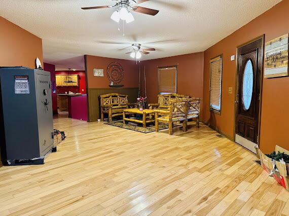 entrance foyer featuring ceiling fan, light hardwood / wood-style flooring, and a textured ceiling