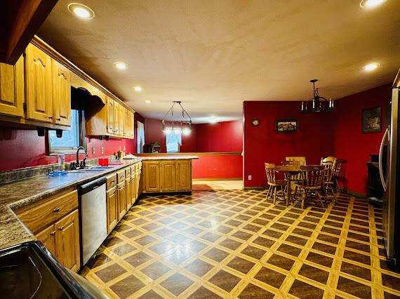 kitchen with dishwasher, sink, kitchen peninsula, refrigerator, and decorative light fixtures