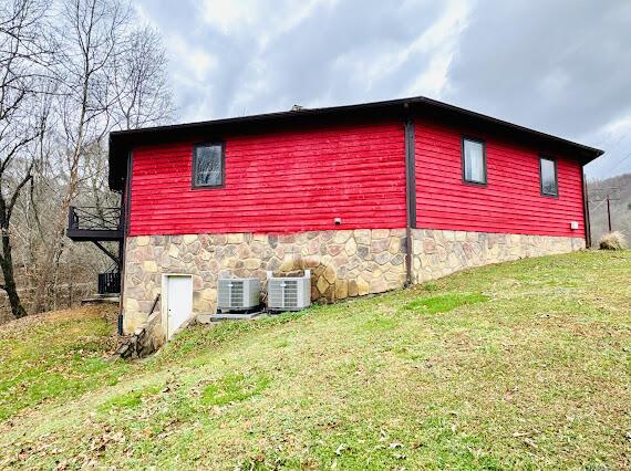 view of home's exterior with central AC unit and a yard