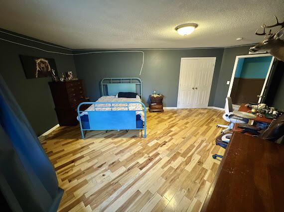 bedroom featuring light hardwood / wood-style floors and a textured ceiling