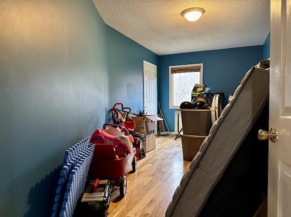 miscellaneous room featuring a textured ceiling and light hardwood / wood-style floors