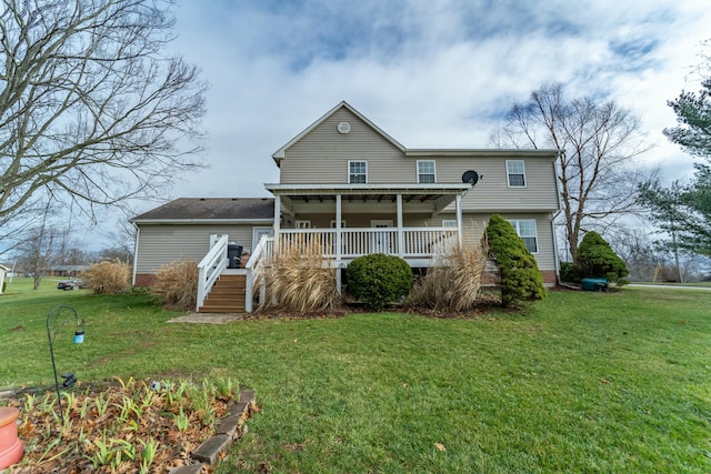 rear view of house with a lawn and covered porch