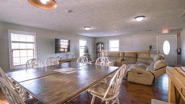 dining space with a textured ceiling and dark hardwood / wood-style floors