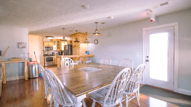 dining area with dark hardwood / wood-style flooring and a textured ceiling