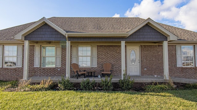 view of front of home with covered porch and a front yard