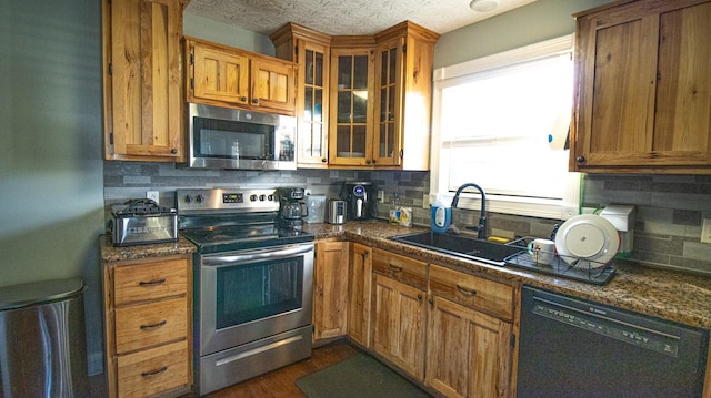 kitchen with sink, appliances with stainless steel finishes, and tasteful backsplash