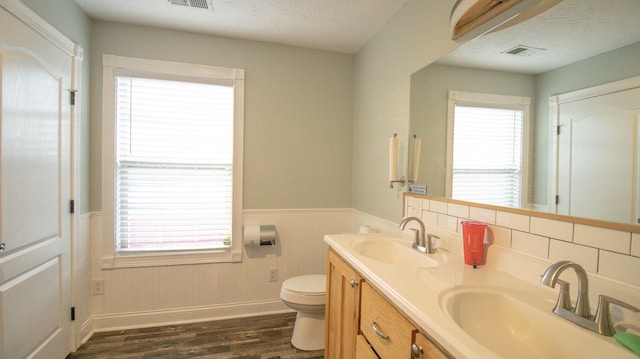 bathroom featuring toilet, vanity, decorative backsplash, hardwood / wood-style flooring, and a textured ceiling