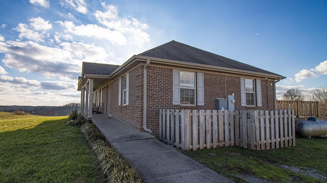 view of side of home with a yard