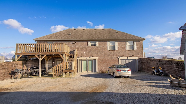 rear view of house featuring a deck and a garage