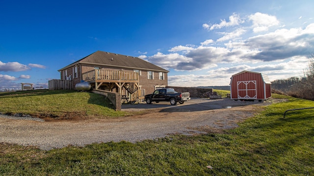 exterior space with a wooden deck, a yard, and a shed