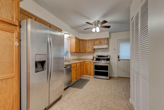 kitchen with ceiling fan, sink, light tile patterned floors, and stainless steel appliances