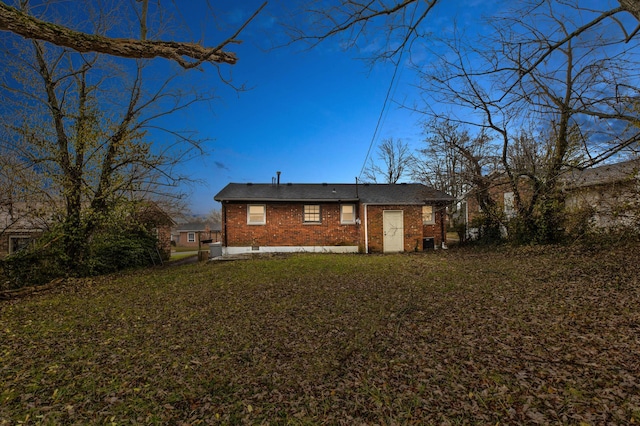 rear view of house featuring a lawn and central air condition unit