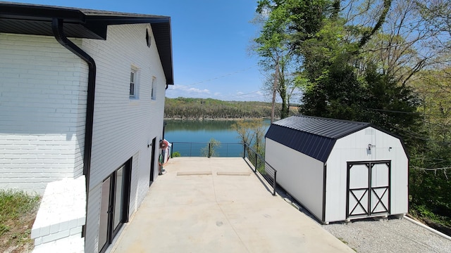 exterior space featuring a water view and a storage shed