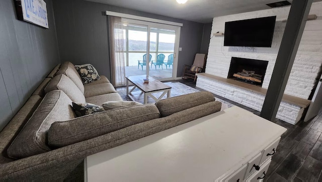 living room with dark hardwood / wood-style flooring and a fireplace