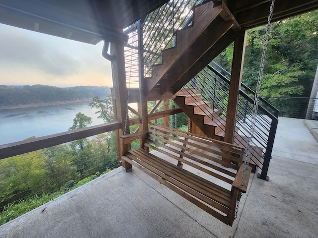 deck at dusk featuring a water view