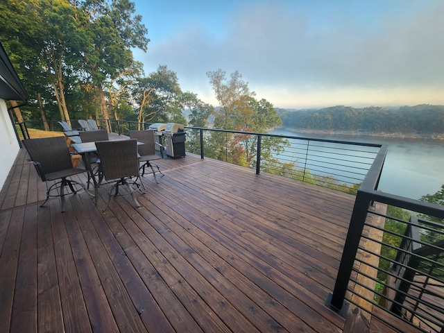 wooden deck with area for grilling and a water view